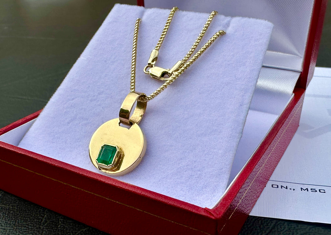#715 - 10-18k 20” Chain & .57ct Emerald Pendant.